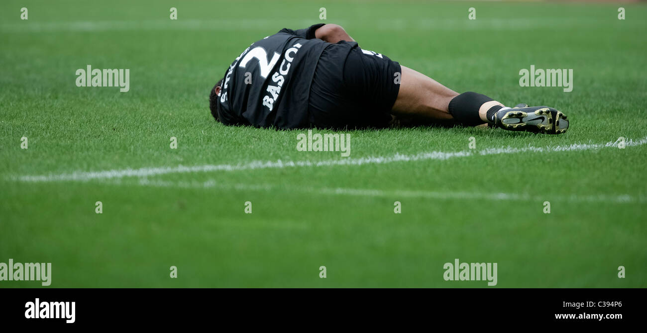 Injured football player lying on the pitch Stock Photo