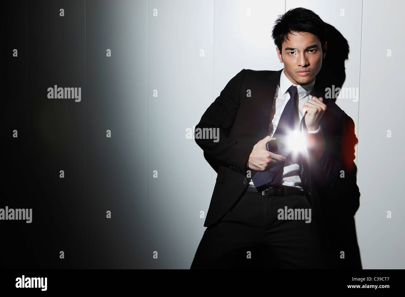 Chinese man in a business suit taking a photo with his camera flash