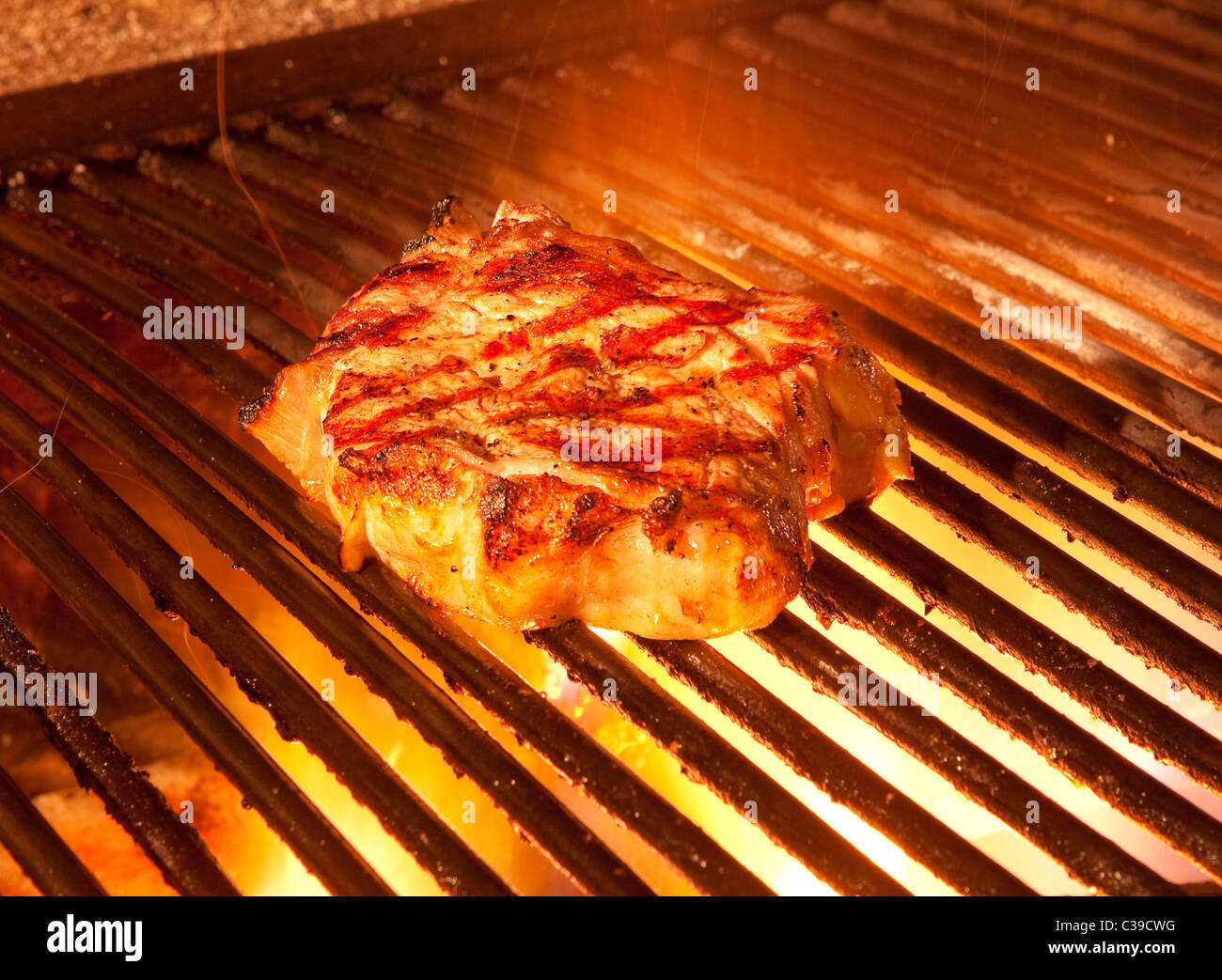 indoor restaurant wooden grill with flames and a big steak Stock Photo