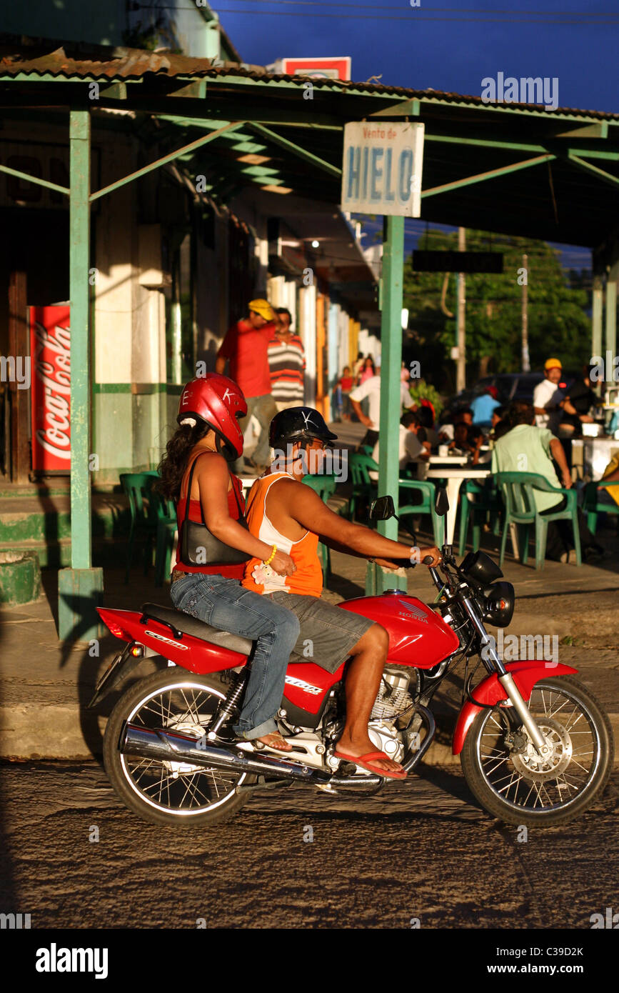 Motorbike traffic in the city with dark rain clouds forming, Leticia, Amazonas, Colombia, South America Stock Photo