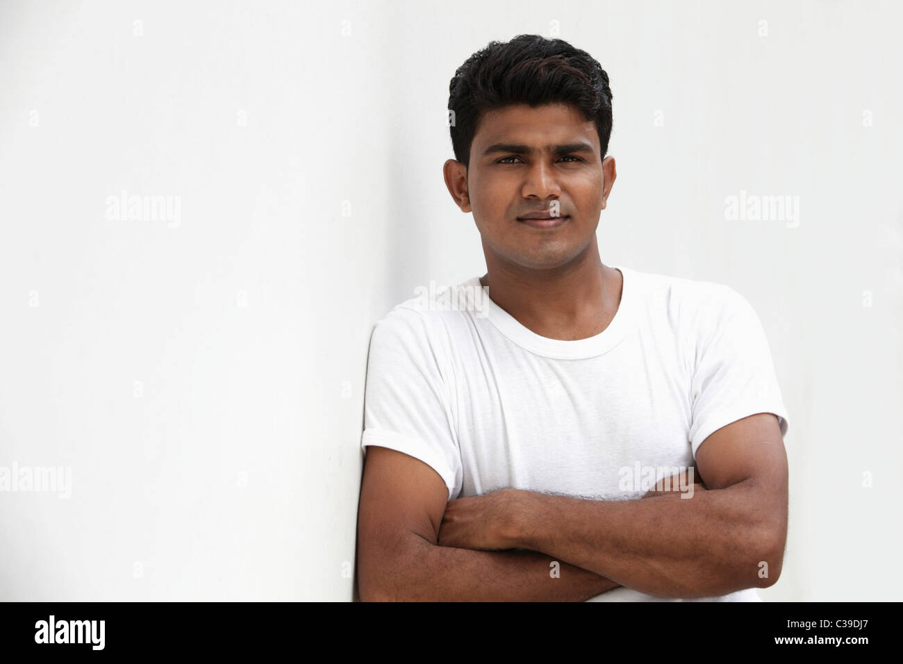 Man leaning against white wall Stock Photo - Alamy