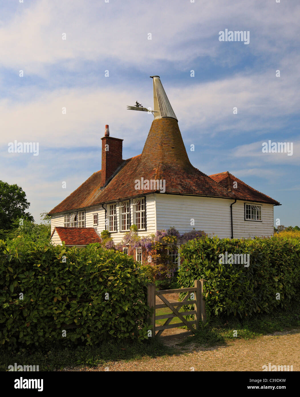 Unusual looking old Oast house with a square and round roof. Stock Photo