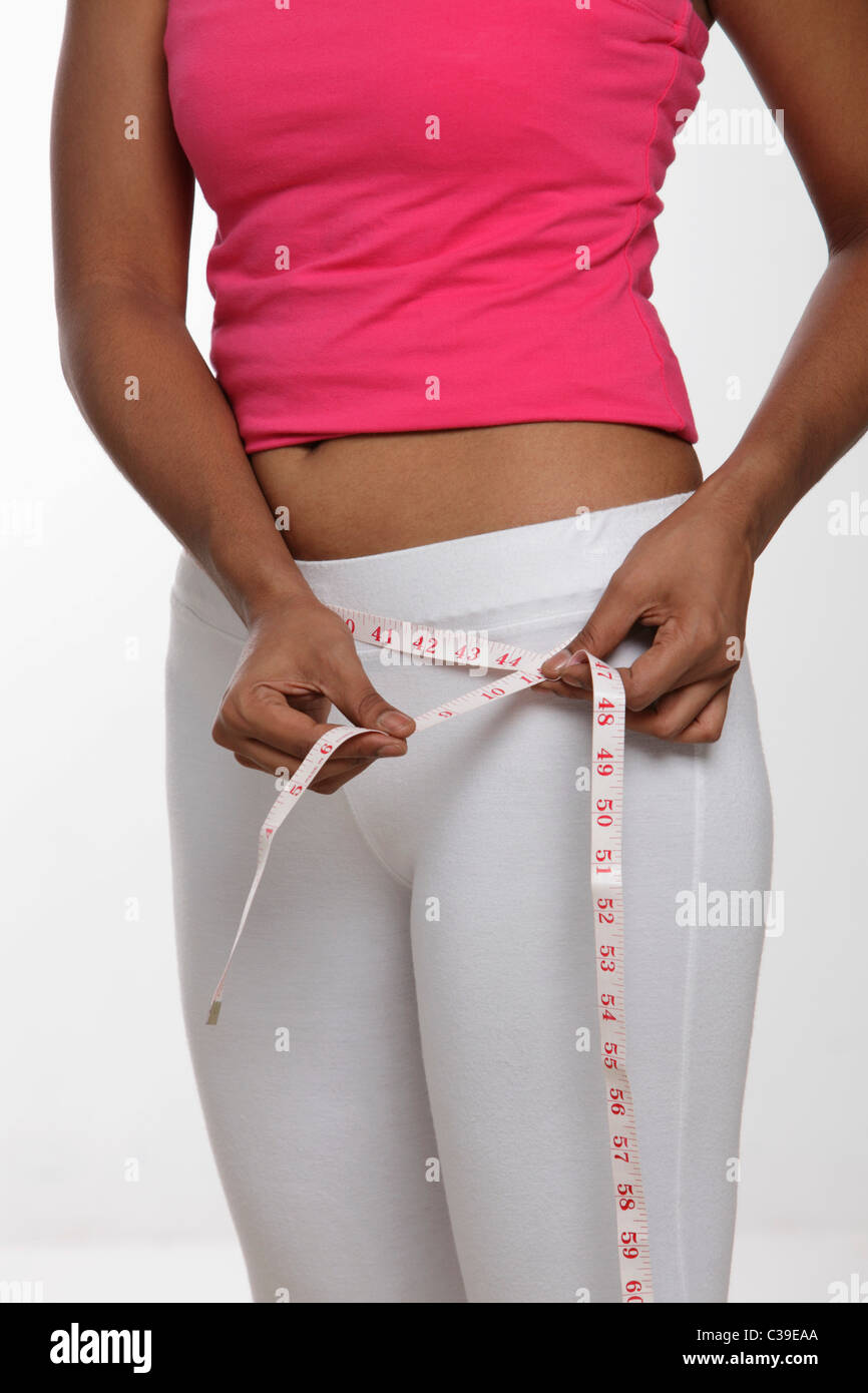 Indian woman measuring her hips with tape measure Stock Photo