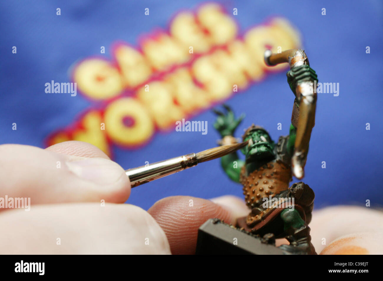 A member of staff paints a figure in a Games Workshop store. Stock Photo