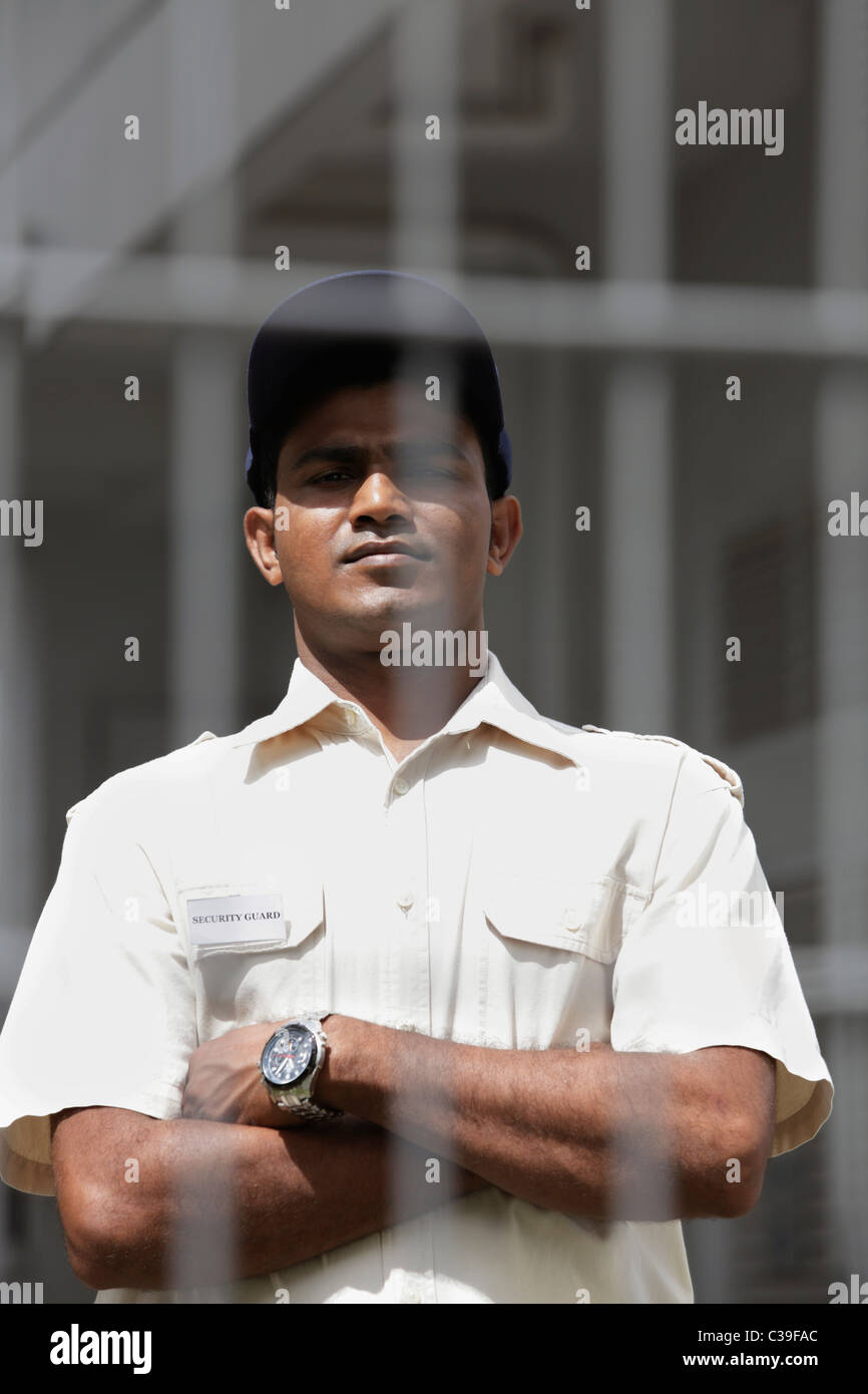 Security guard looking from behind fence Stock Photo Alamy