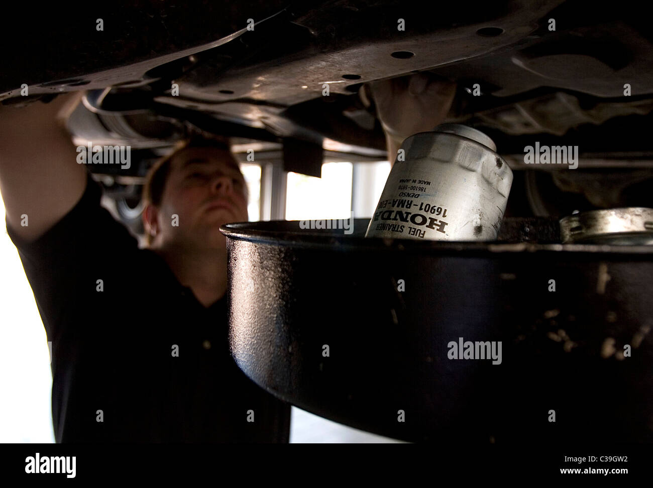 A dealership mechanic servicing a HONDA motor car. Stock Photo