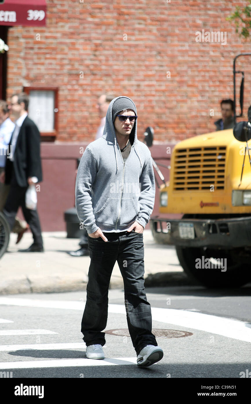 Justin Timberlake wearing a grey hoodie and sunglasses walking in SoHo ...