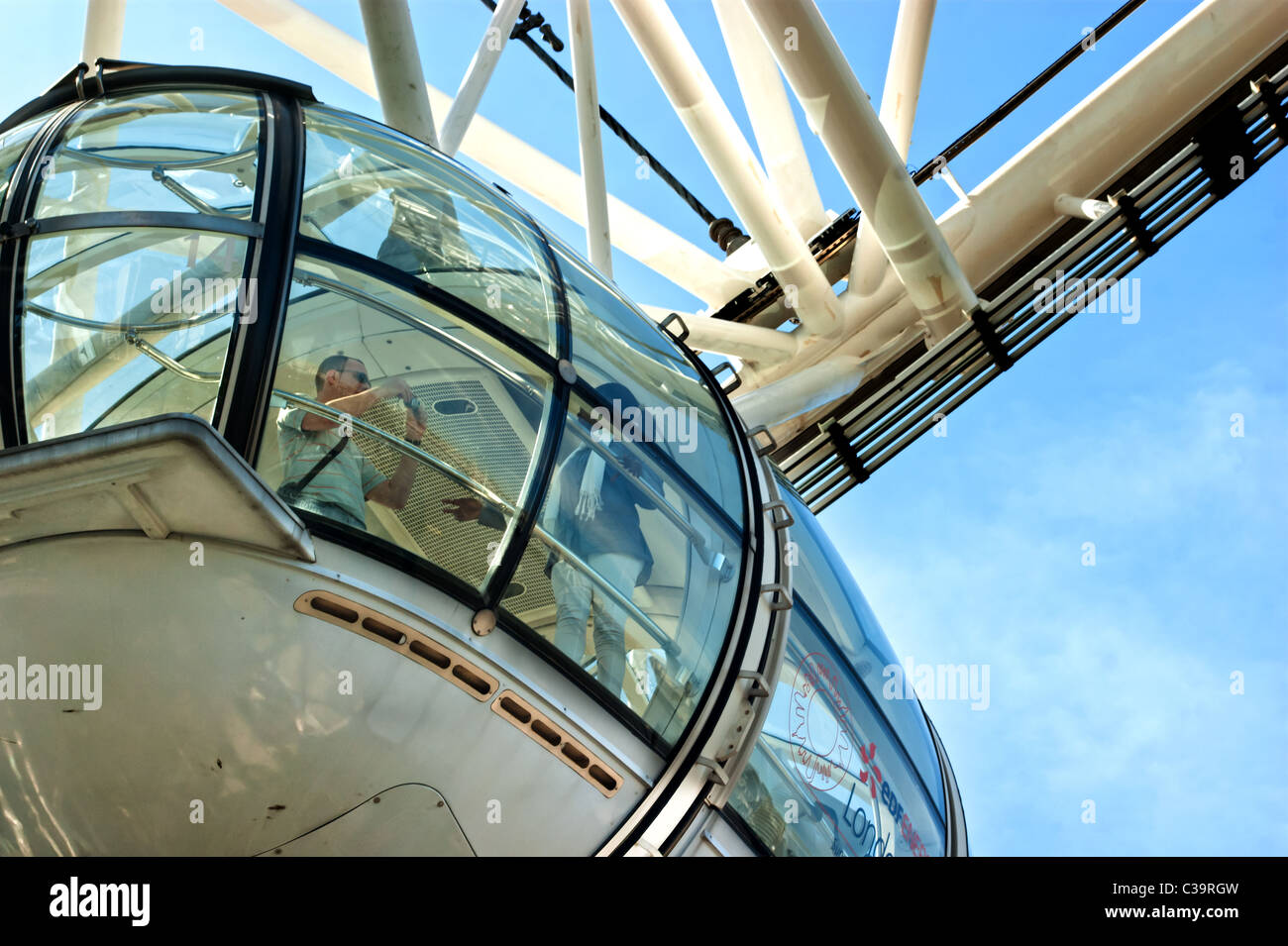 A close-up shot of one of the cars on the London eye. A  couple on board,  take fotos of each other. 2011. Stock Photo
