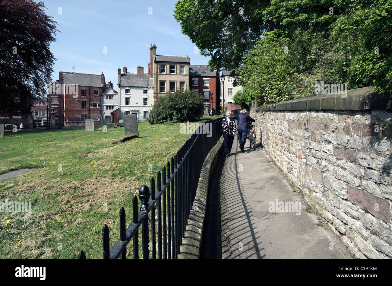 Church Walk, Wirksworth, Derbyshire - a footpath route around the churchyard (left) of St Mary's Church, next to the town centre Stock Photo