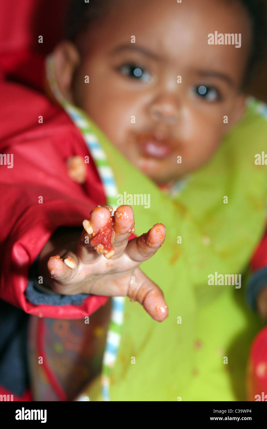 Nine-month-old girl with food on her fingers Stock Photo - Alamy