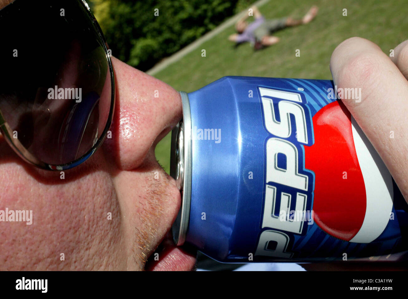 A man drinking a can of Pepsi cola Stock Photo Alamy