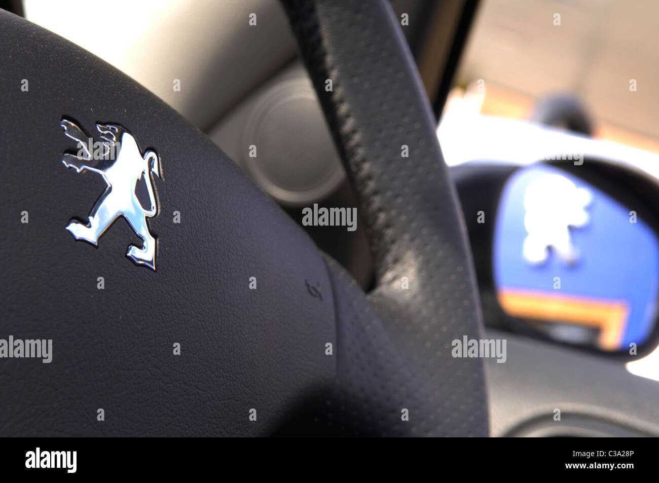 The branded steering wheel inside a Peugeot car. Stock Photo