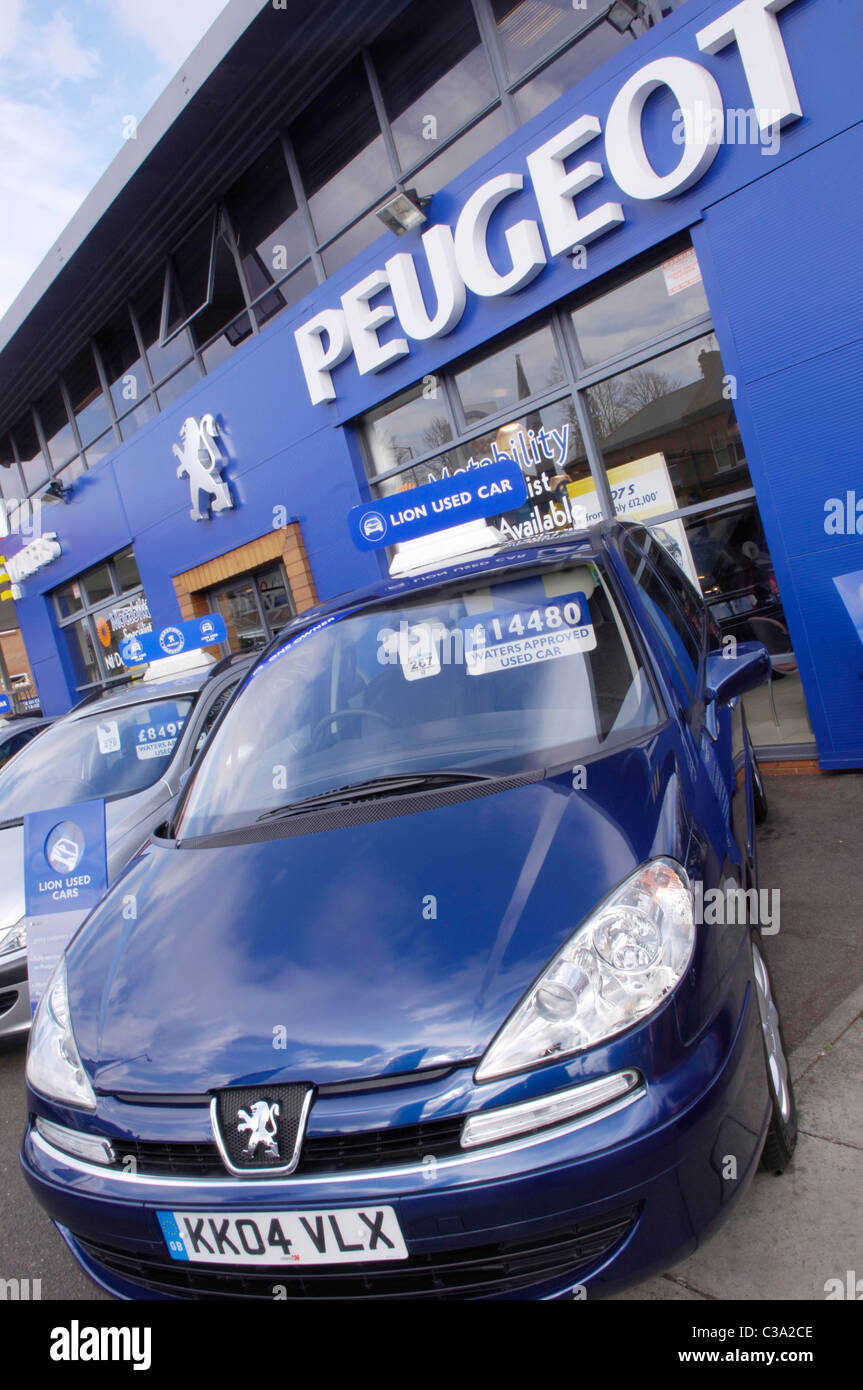 Second hand cars on display outside a Peugeot car dealership. Stock Photo