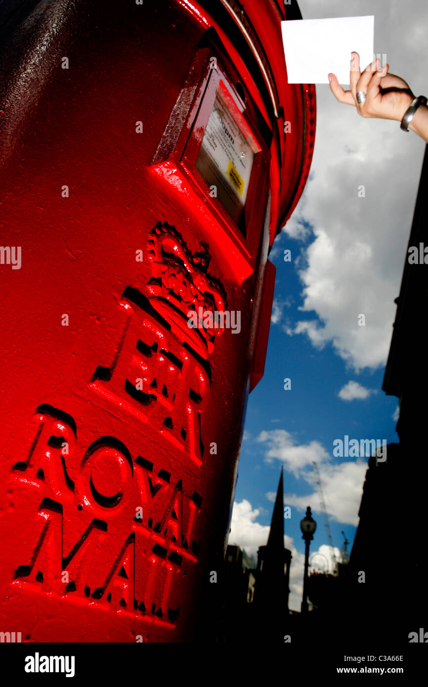 Letter Post System Letters Being posted in a Royal Mail post box Stock Photo - Alamy