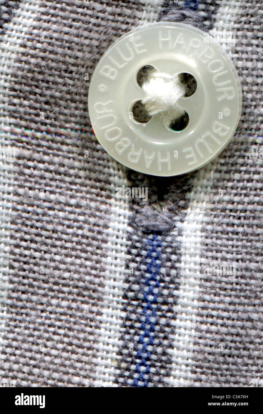 Detailed image of a shirt button and button hole on a mens striped Blue harbor - trade mark of Marks and Spencer (M&S) shirt Stock Photo