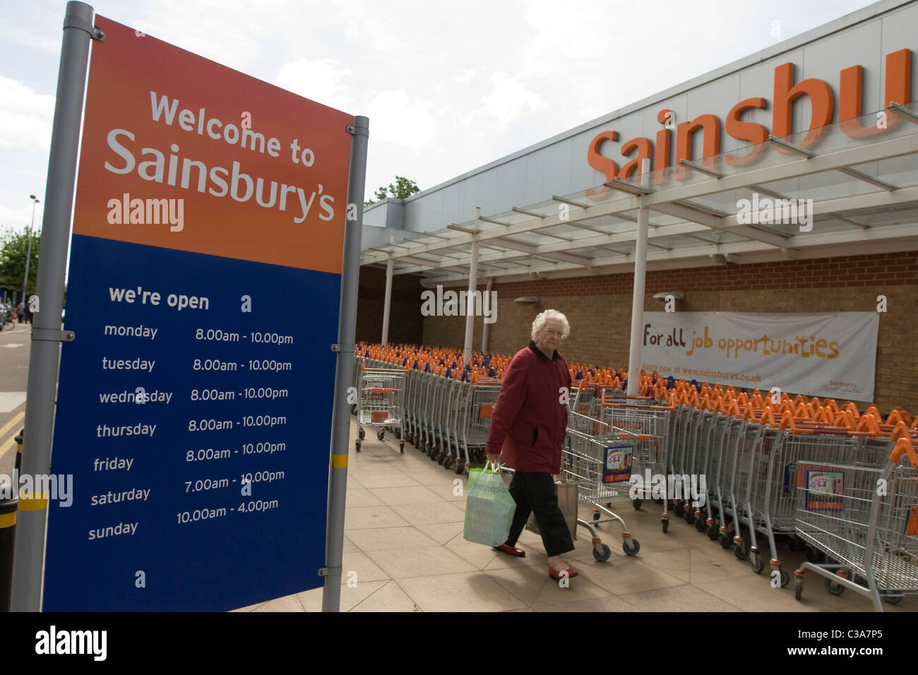A customer passing the outside of a Sainsbury's store Stock Photo Alamy