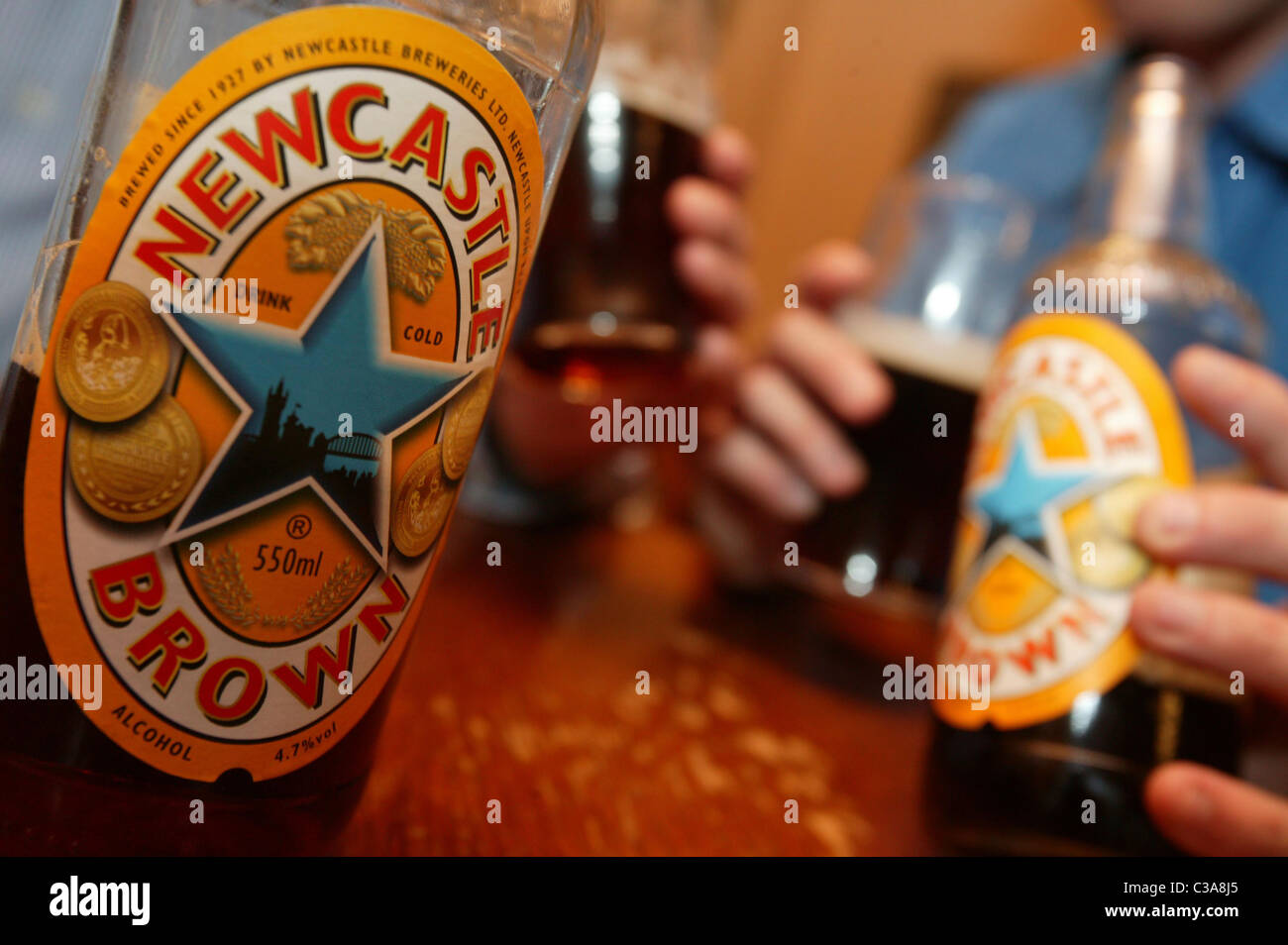 Two men drinking Newcastle Brown Ale; a Scottish and Newcastle brand. Stock Photo