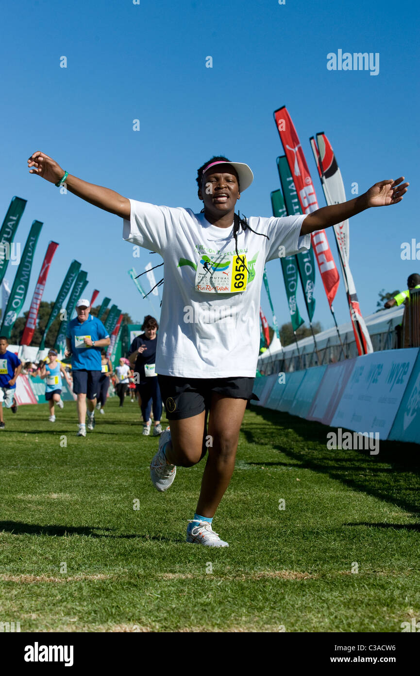 Runner celebrates at the finish of the 5km Fun Run, Two Oceans Marathon, Cape Town, South Africa Stock Photo