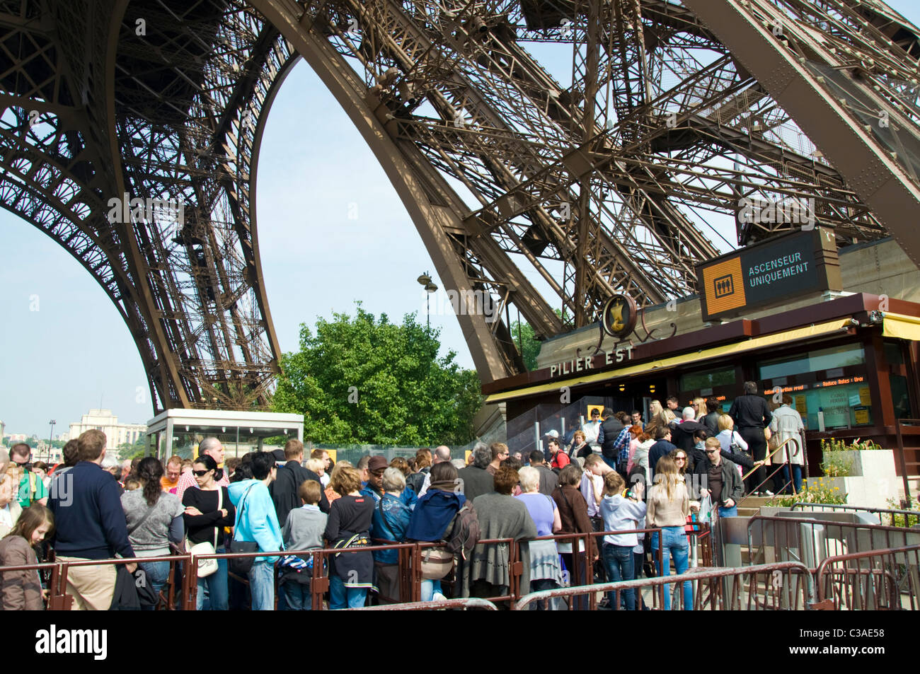 Tourists queue to go up the Eiffel Tower in Paris France Stock Photo