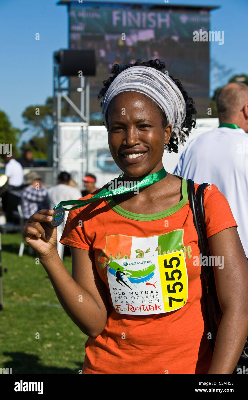 Runner shows the medal of the 5km Fun Run, Two Oceans Marathon, Cape Town, South Africa Stock Photo