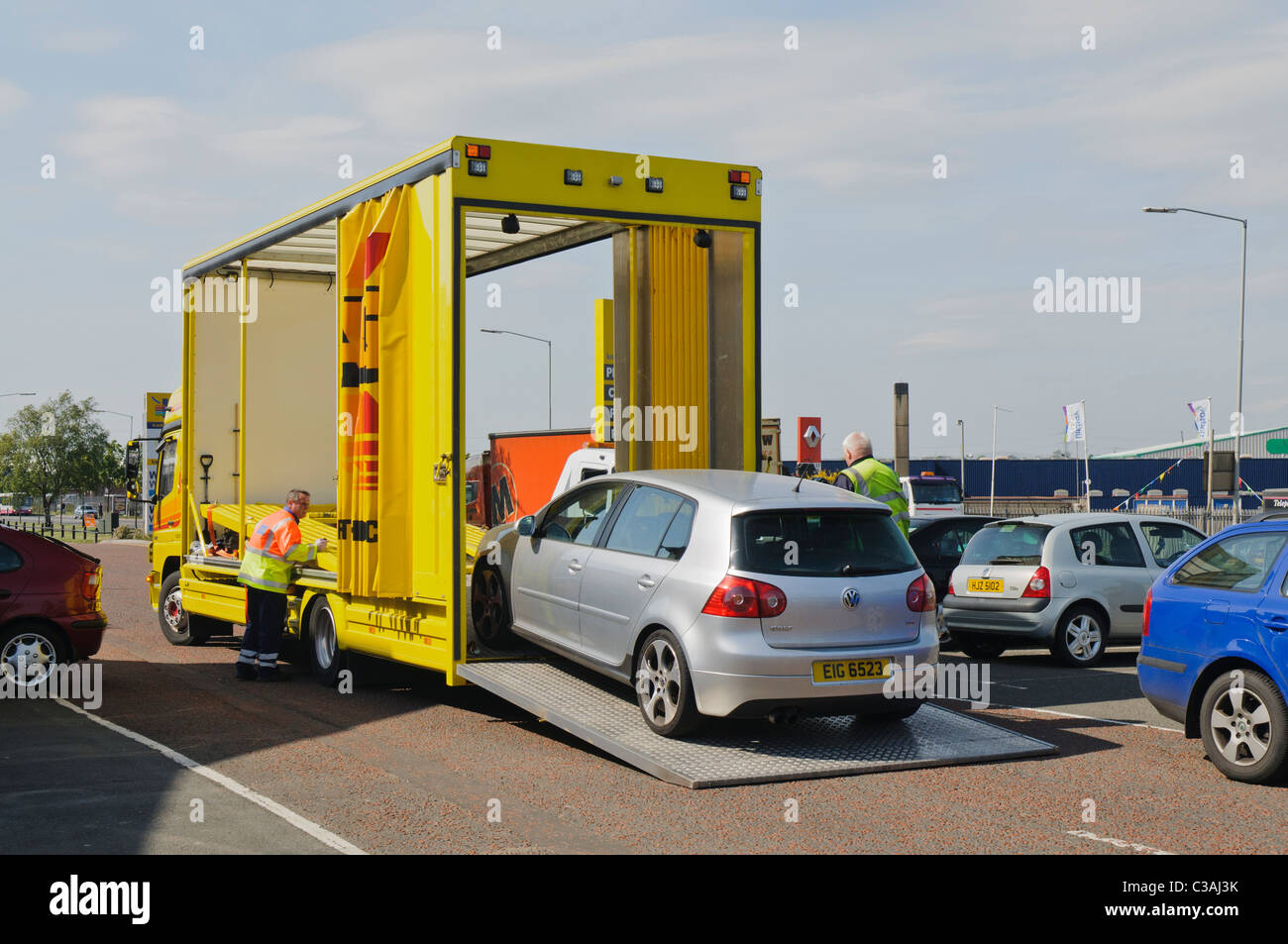 Silver Volkswagen Golf loaded onto a recovery truck Stock Photo
