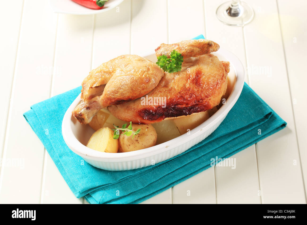 Roast chicken and new potatoes in a casserole dish Stock Photo Alamy