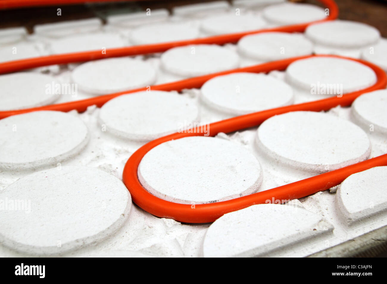 radiant floor heating tube red pipe curved in white circle pattern