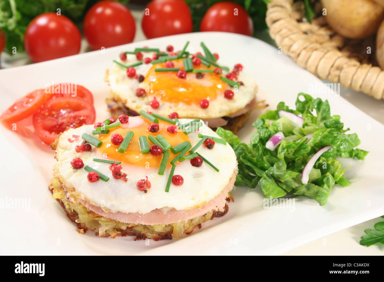 Potato pancakes with ham, egg, red pepper, chives and fresh salad Stock