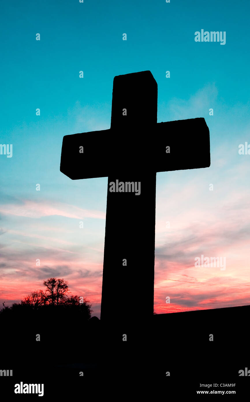 Silhouette of a cross against a colorful sky at dusk (Dalham in Sufolk) Stock Photo