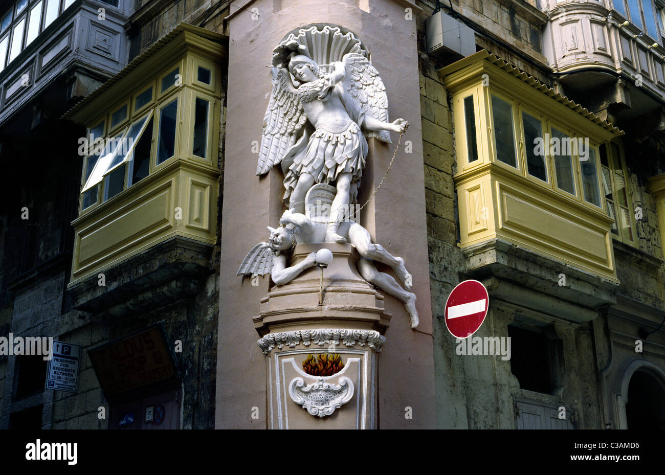 Archangel Michael trampels Satan (War in Heaven) shrine on a street corner in the Maltese capital of Valletta. Stock Photo