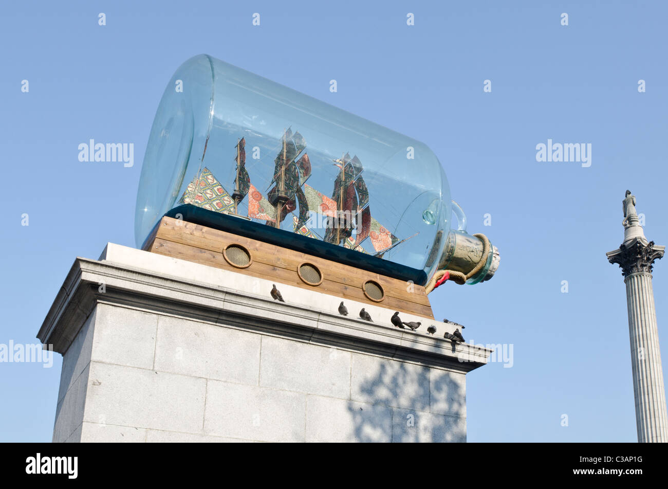 Nelson's Ship in a Bottle on the Fourth Plinth in Trafalgar Square. Nelson's Column in background London Uk Stock Photo