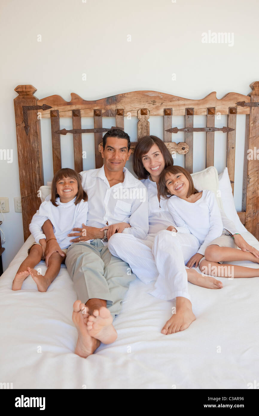 parents and two daughters on bed Stock Photo