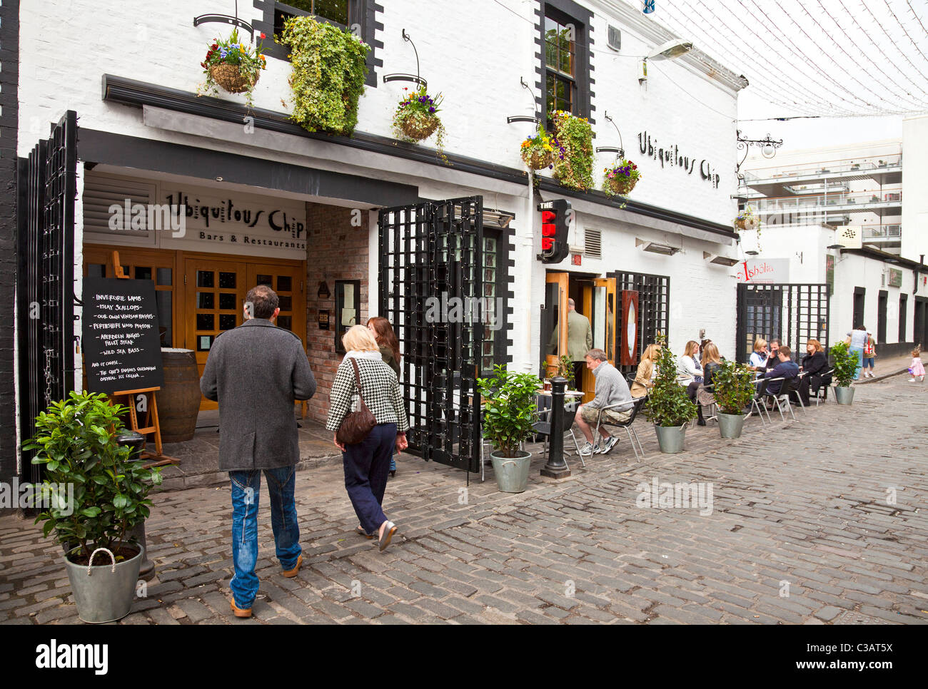 Two people entering the Ubiquitous Chip restaurant Ashton Lane, West