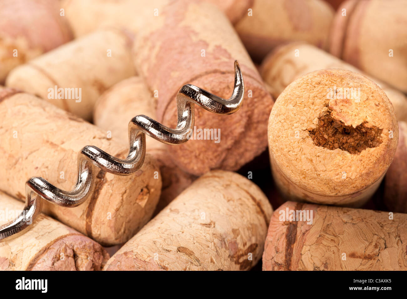 A close up of a corkscrew and wine bottle corks, also known as bottle stoppers. Stock Photo