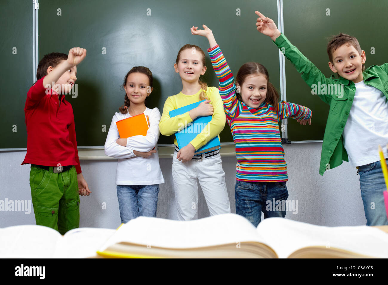 Portrait of five pupils having fun in classroom Stock Photo - Alamy