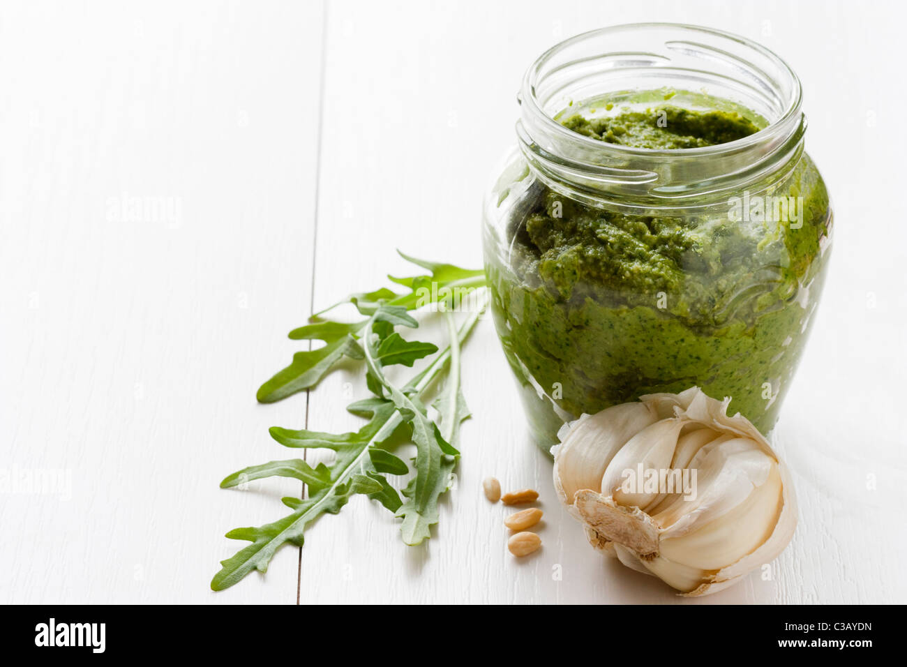 A glass of fresh prepared rocket pesto with garlic and pine nuts. Stock Photo
