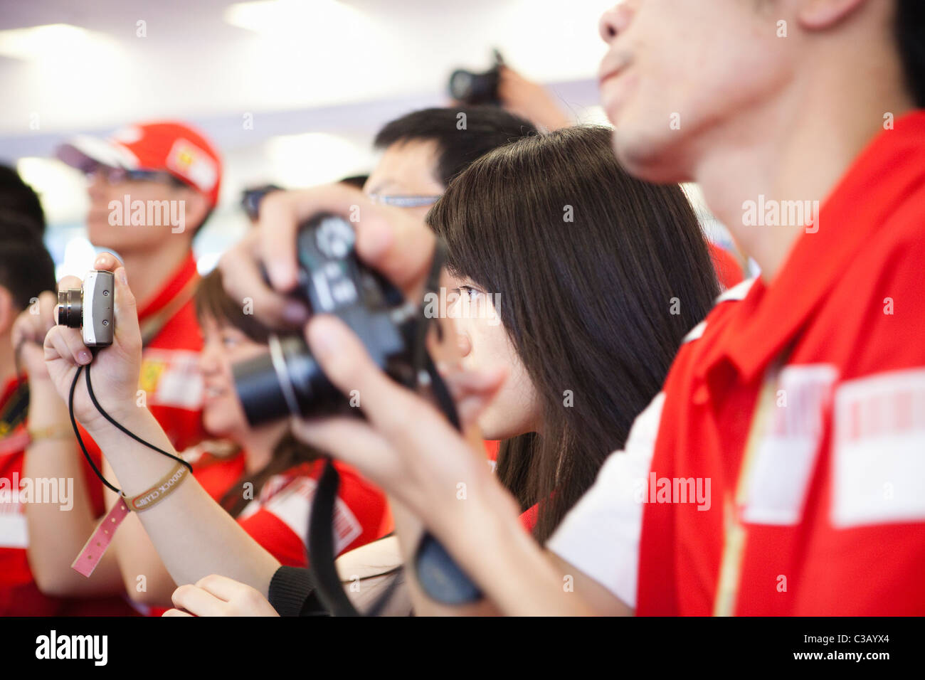 shanghai: beautiful young woman holding a camera in ferrari paddock Stock Photo