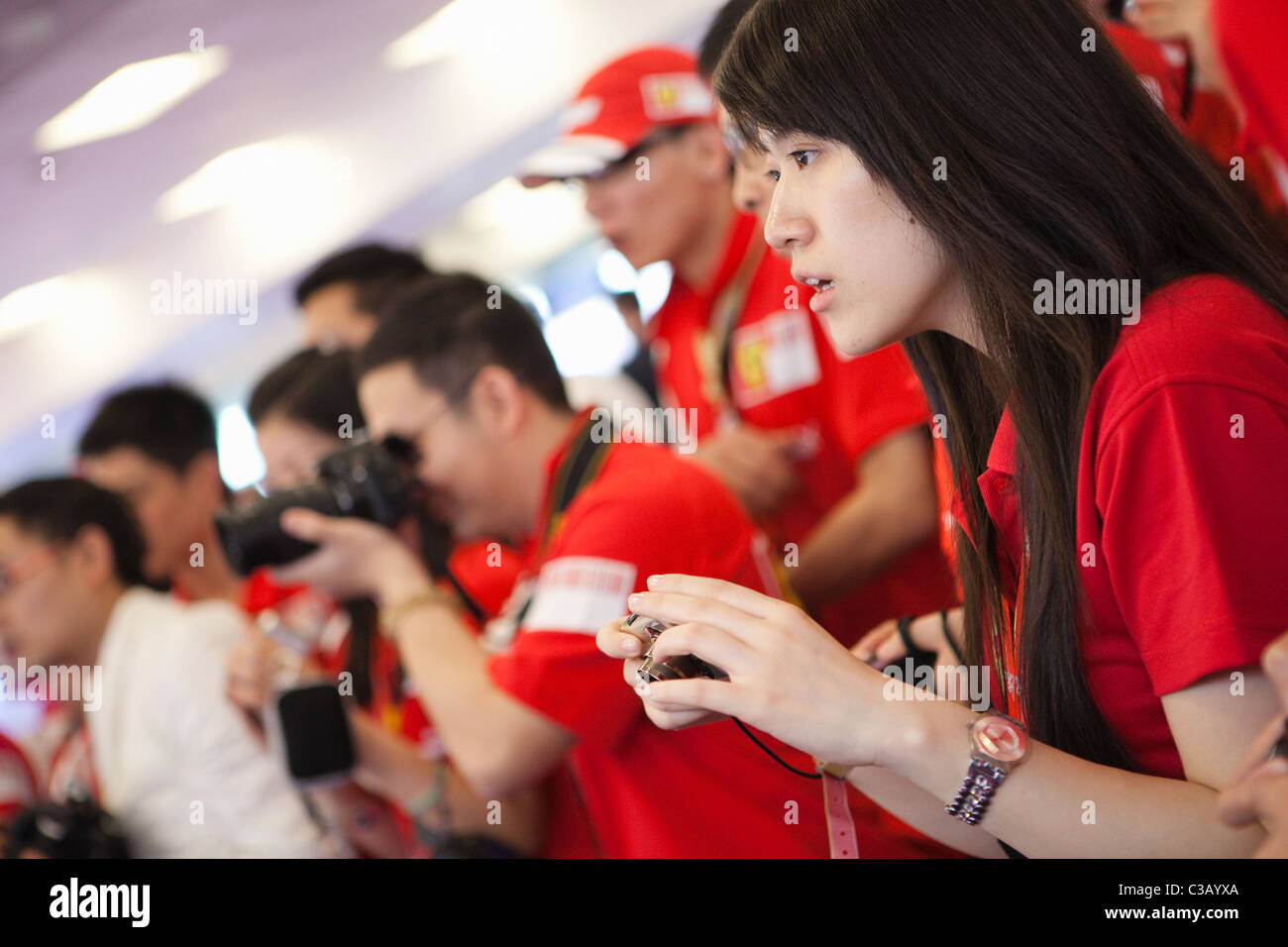 shanghai: beautiful young woman holding a camera in ferrari paddock Stock Photo