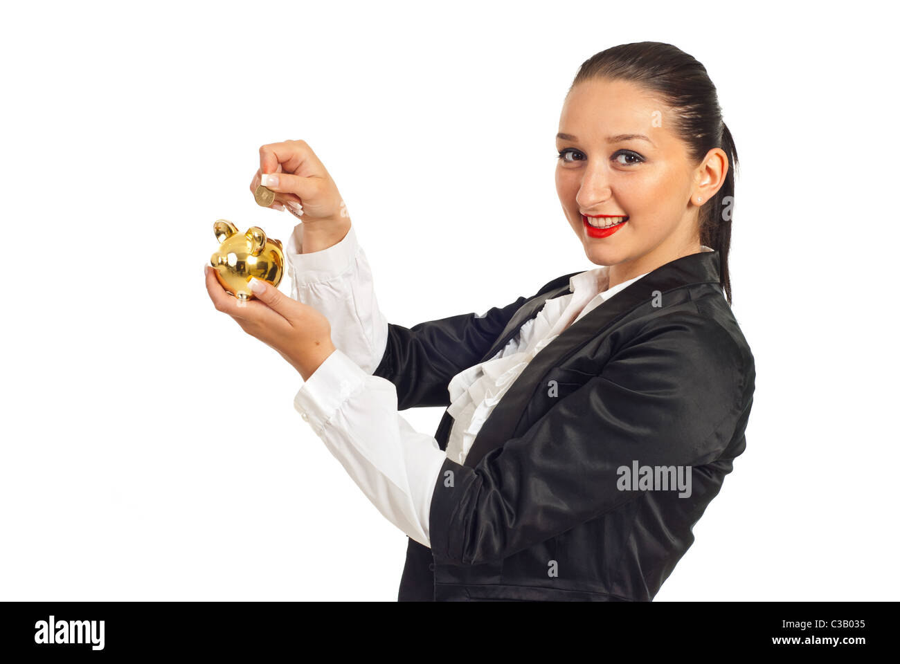 Young woman putting a gold coin in a piggy bank hi-res stock ...