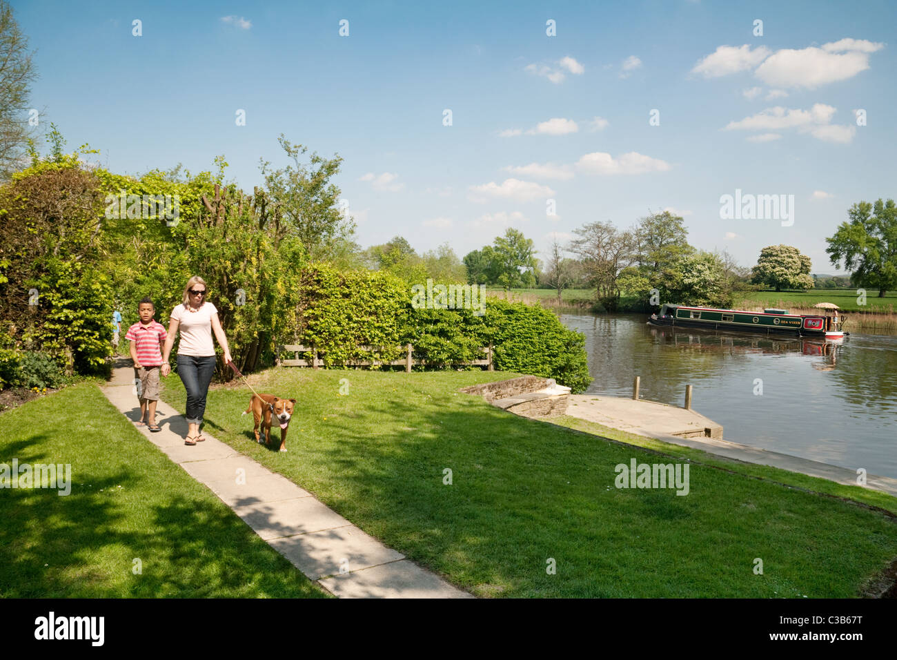Dog walking UK; A family walking the dog on the river Thames path at Wallingford, Oxfordshire, England UK Stock Photo