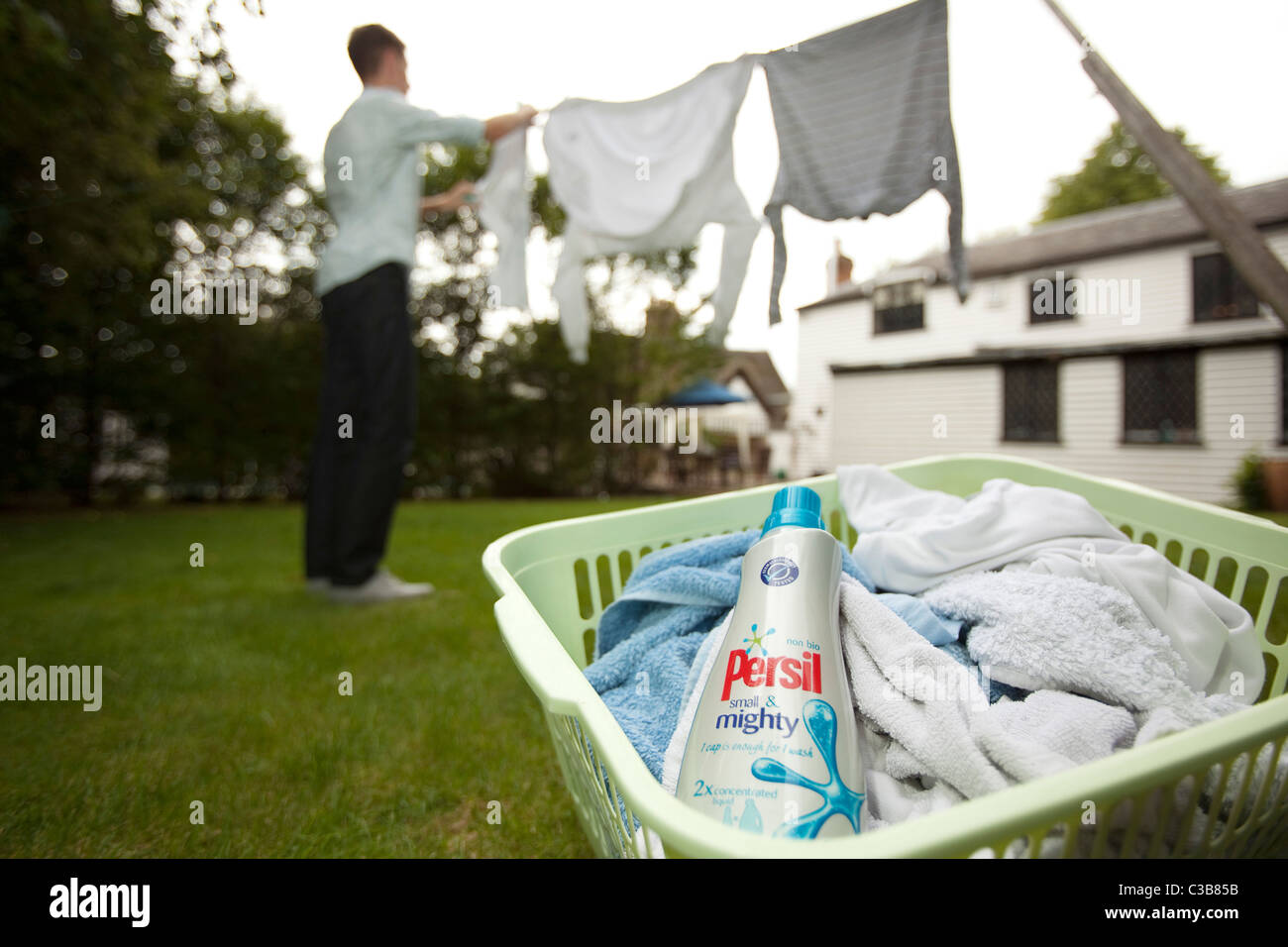 A young man hangs up his washing. Stock Photo