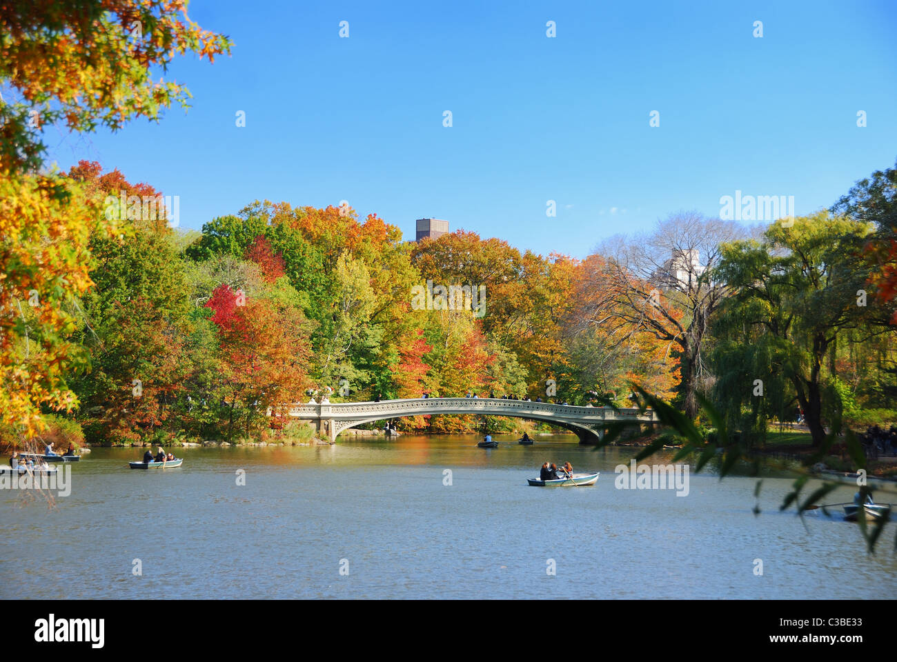 New York City Central Park panorama view in Autumn with Manhattan skyscrapers and colorful trees with Bow Bridge over lake w Stock Photo