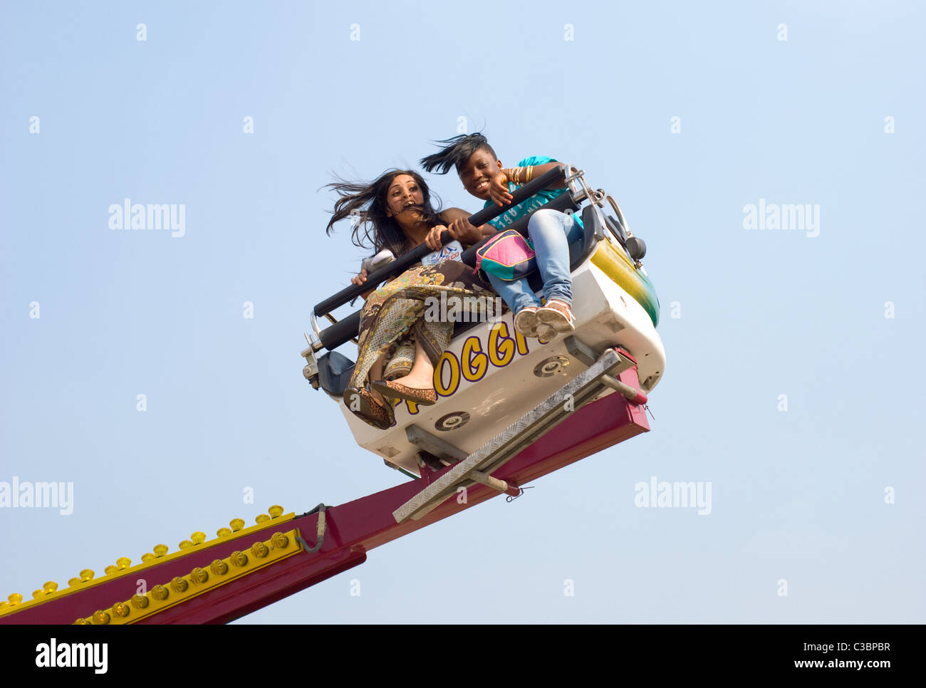 Two Girls on Fun Fair Ride on Wanstead Flats Stock Photo