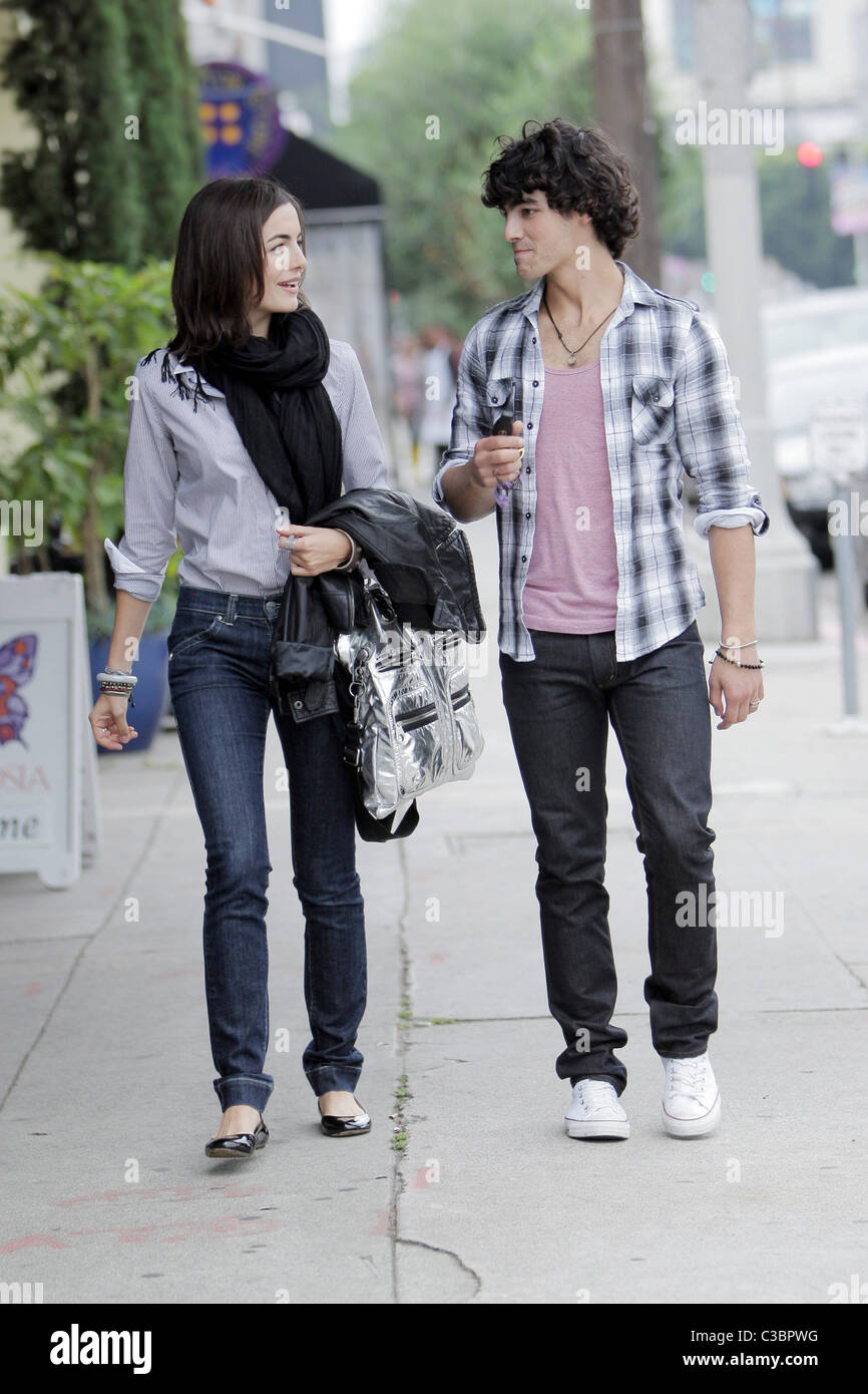 Joe Jonas of the Jonas Brothers and Camilla Belle walking down the