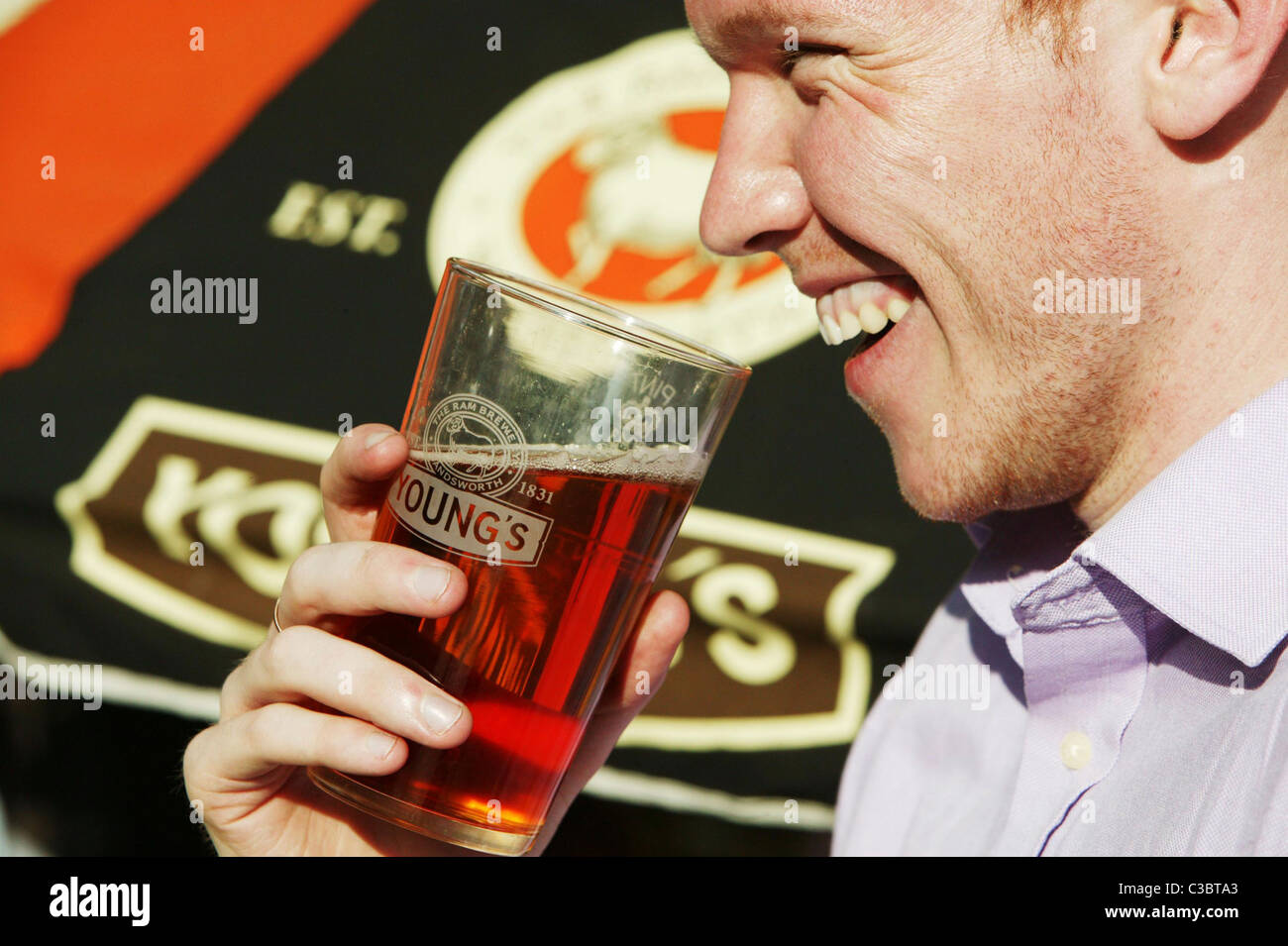 A person drinking a pint of beer at a Young & Co's Brewery. Stock Photo
