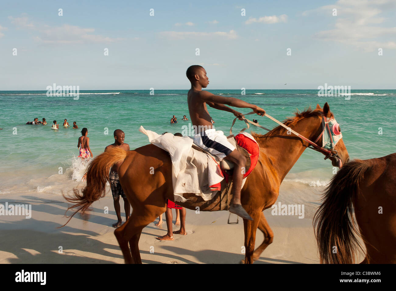 A local boy rides a horse along Hellshire beach in Jamaica. Stock Photo