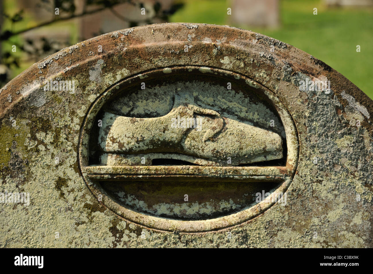 Detail of gravestone with shoe motif, Church of Saint Kentigern. Caldbeck, Cumbria, England, United Kingdom, Europe. Stock Photo