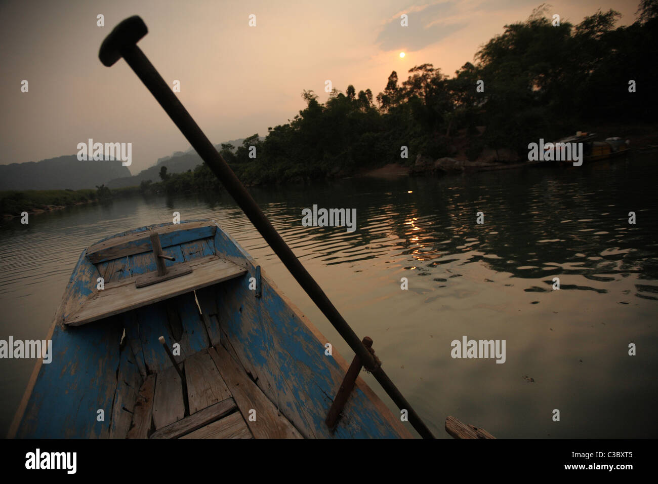 On board a small wooden boat on the River Son, at Son Trach, Phong Nha Ke Bang National Park, in Vietnam late one afternoon Stock Photo