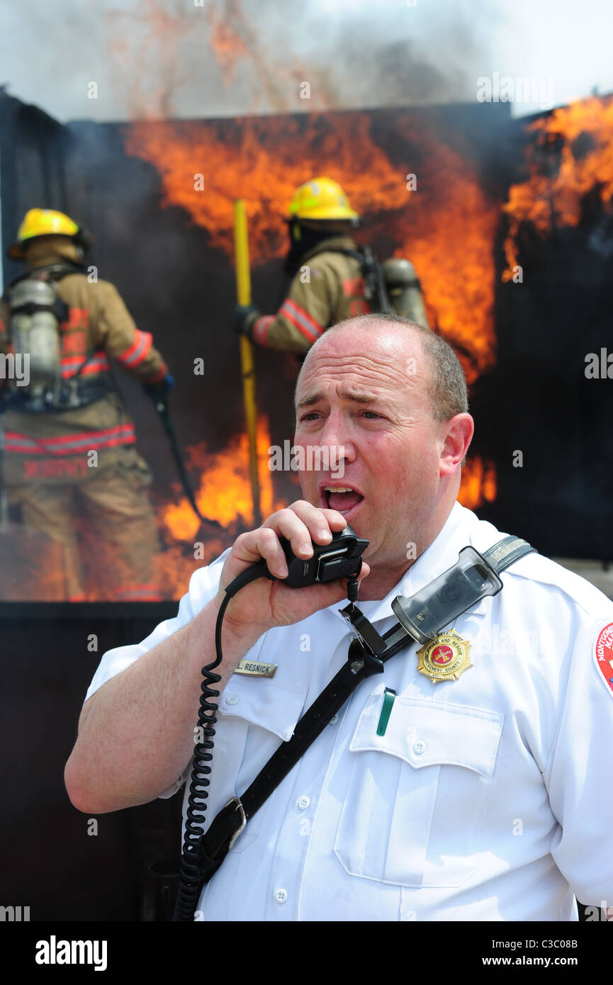 USA Fire Emergency firefighters battling blaze in shipping container  Battalion Fire Chief on radio Stock Photo