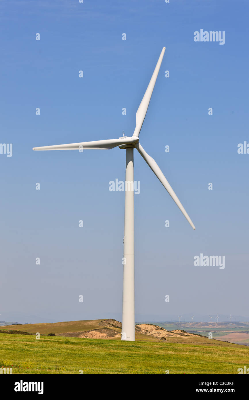 Windmill in green field over cloudy sky Stock Photo